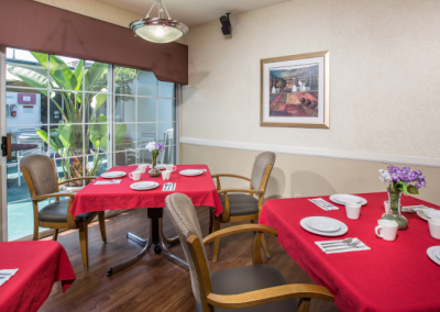 Anaheim Terrace dining room with bright red tablecloths and fresh flowers on the tables